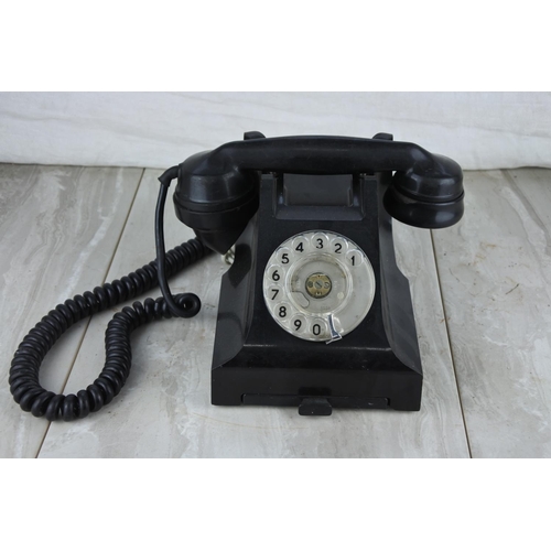 75 - A vintage black rotary dial telephone.