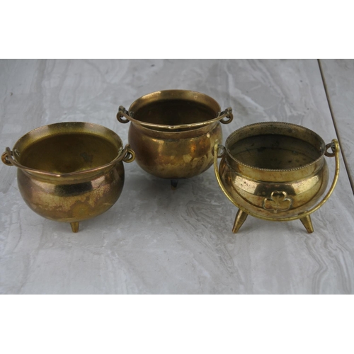 84 - Three small brass cauldrons.