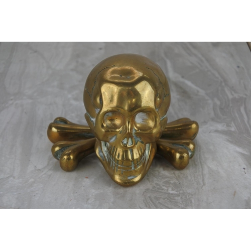 91 - An unusual brass skull and cross bones paper weight.