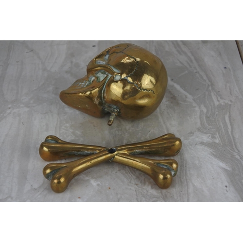 91 - An unusual brass skull and cross bones paper weight.