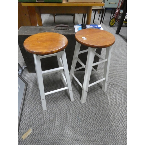 672 - A pair of circular topped wooden stools.