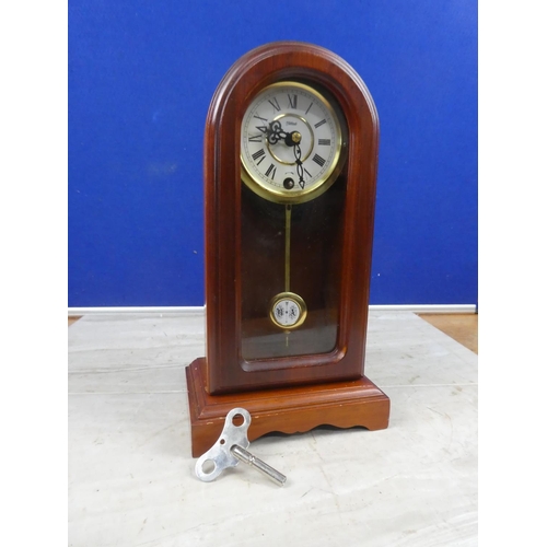 676 - An arch topped mantle clock and key.