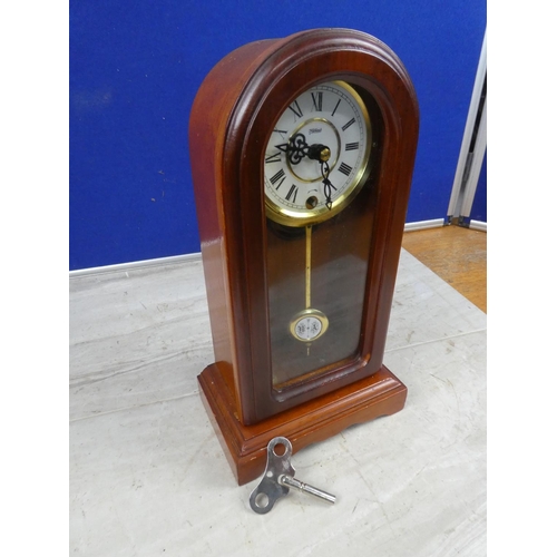 676 - An arch topped mantle clock and key.