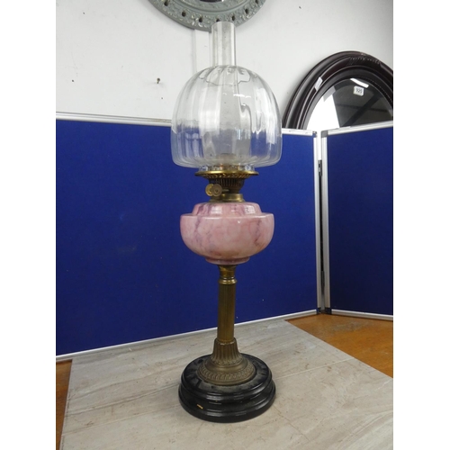 683 - A stunning antique oil lamp with pink marble font and clear glass shade.