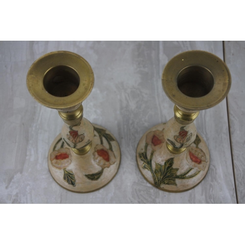 312 - A pair of Indian brass decorated candlesticks.