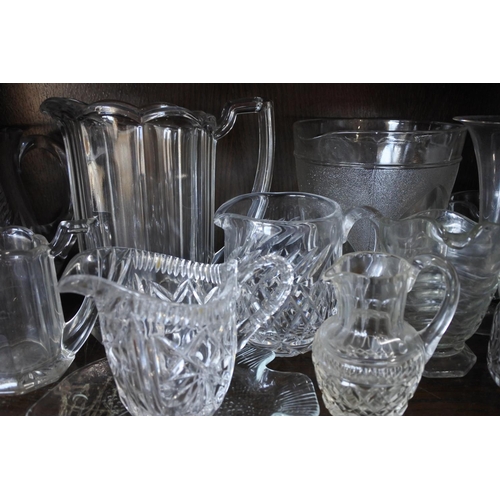 585 - A large collection of glass jugs and more.