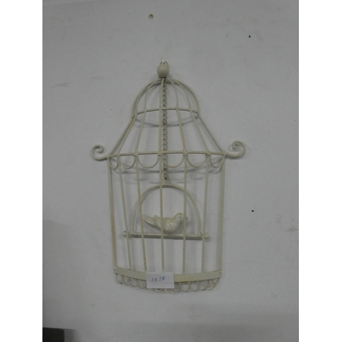 1038 - A decorative wall hanging of a bird in a cage.