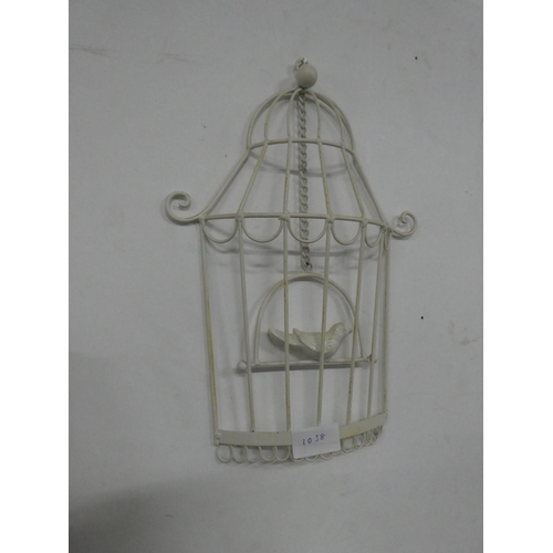 1038 - A decorative wall hanging of a bird in a cage.