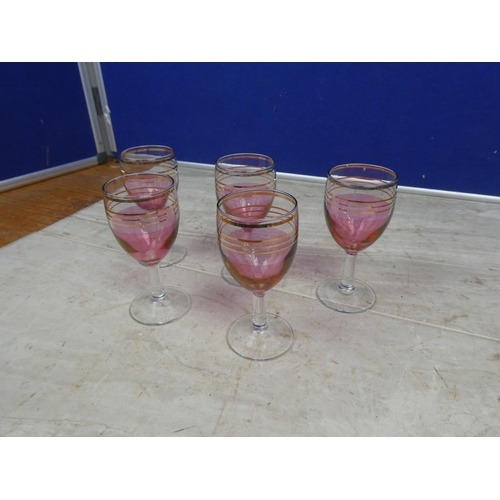 105 - A set of five ruby and gilt sherry glasses.