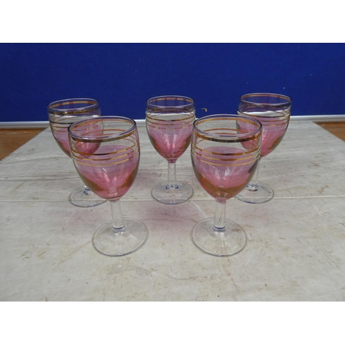 105 - A set of five ruby and gilt sherry glasses.