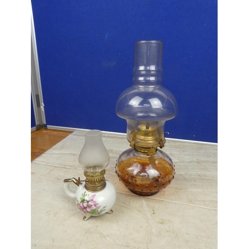 127 - An glass oil lamp and shade and a miniature ceramic based finger lamp and shade.  Approx 30cm.