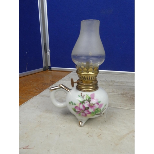 127 - An glass oil lamp and shade and a miniature ceramic based finger lamp and shade.  Approx 30cm.