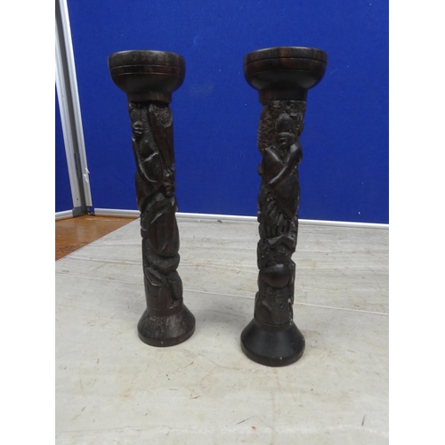 176 - A pair of carved wooden candlesticks.  Approx 23cm.