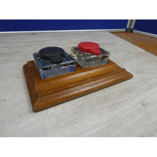 180 - A vintage wooden inkwell stand with two glass inkwells.