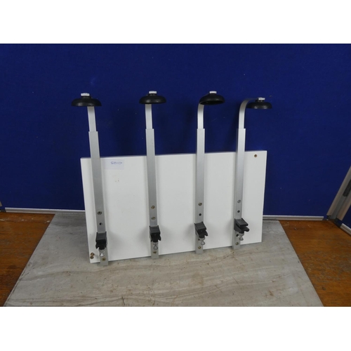 252 - A set of 4 spirit bottle holders mounted on a board.