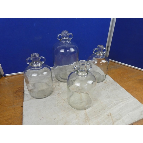 287 - Three small clear glass demijohn bottles and another.