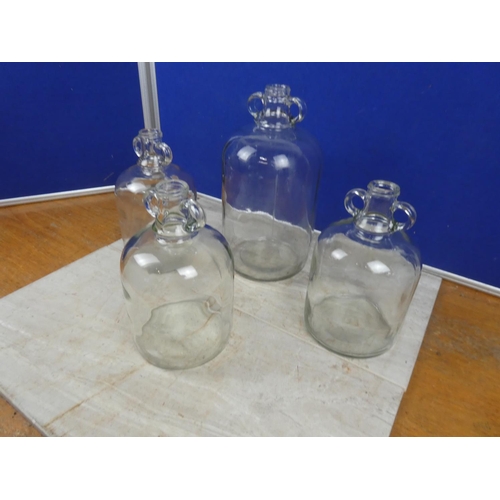 287 - Three small clear glass demijohn bottles and another.