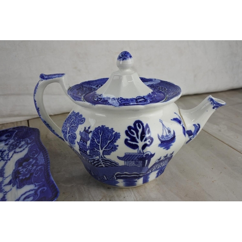 387 - A Willow patterned teapot, six side plates and a square floral pattern blue platter.