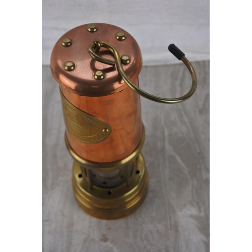 395 - A brass and copper mining lamp. Approx 22cm.