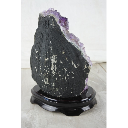 522 - A large piece of amethyst crystal mounted on a presentation stand.