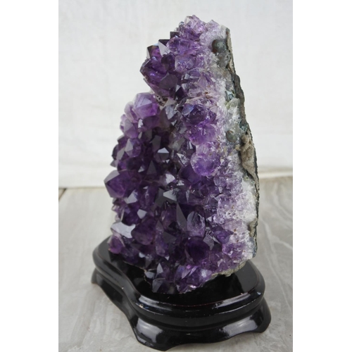 522 - A large piece of amethyst crystal mounted on a presentation stand.