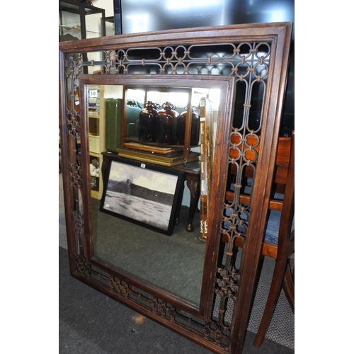 549 - A large wooden and wrought iron framed wall mirror. Approx 90x110cm.