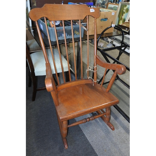 598 - A wooden high backed rocking chair.