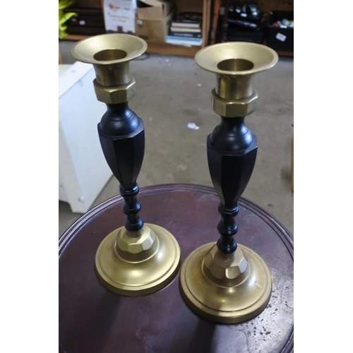 858 - A Logan's mahogany plantstand and a pair of brass and painted candlesticks.  Approx 88cm.