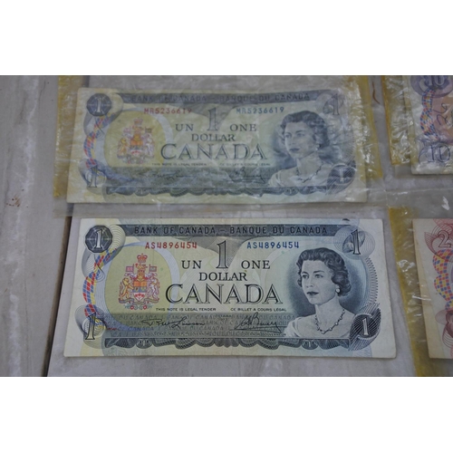 881 - Two Bank of Canada One Dollar notes, one Two Dollar note and a Ten Dollar note.