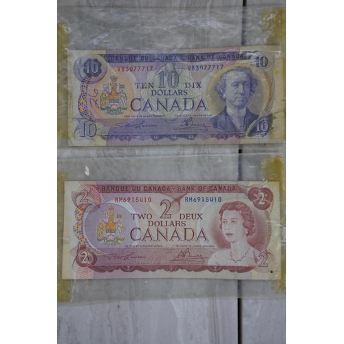 881 - Two Bank of Canada One Dollar notes, one Two Dollar note and a Ten Dollar note.