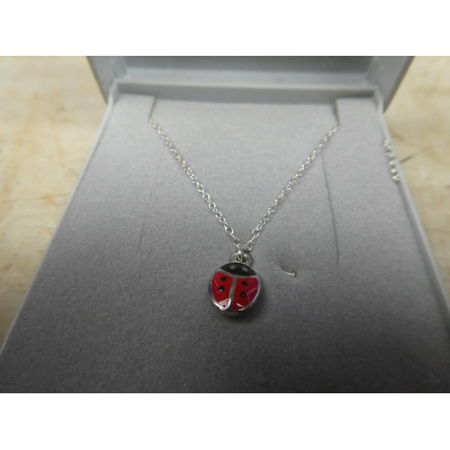 908 - A sterling silver chain and ladybird pendant.