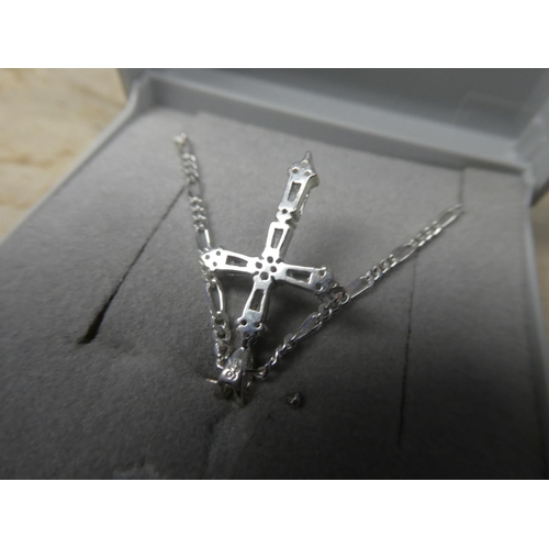 910 - A sterling silver chain and cubic zirconia cross pendant.