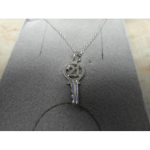 911 - A sterling silver chain and 21 key pendant.