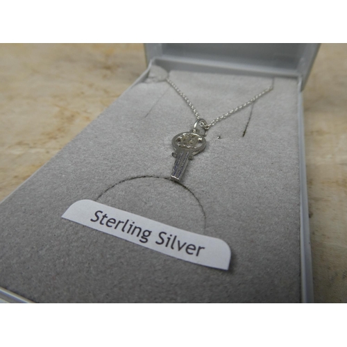 911 - A sterling silver chain and 21 key pendant.