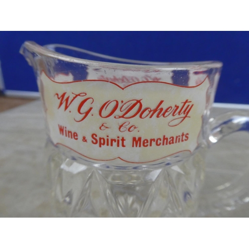 935 - A vintage W G O'Doherty Wine and Spirits Merchant glass jug (a/f).