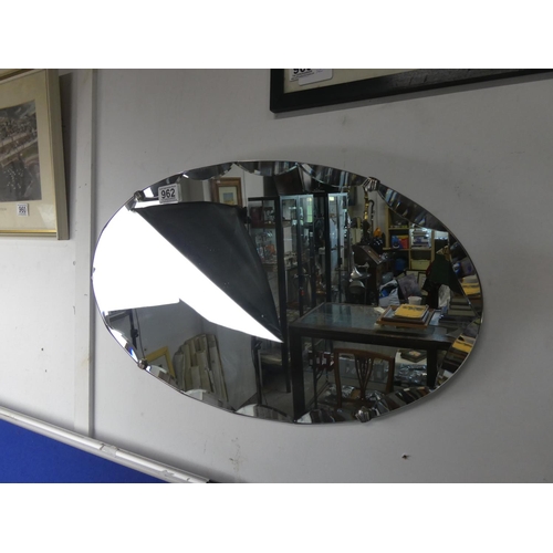 962 - An unframed vintage mirror with bevelled detail.  Approx 60x35cm.