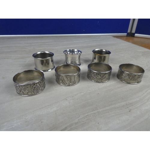 968 - Four silver plated pattern napkin rings and three others.