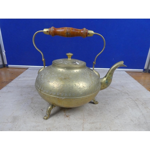 693 - A vintage brass teapot with wooden handle.