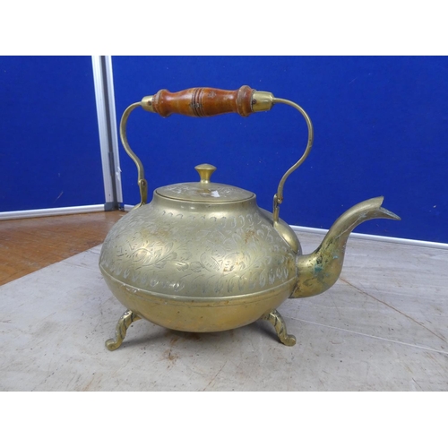 693 - A vintage brass teapot with wooden handle.