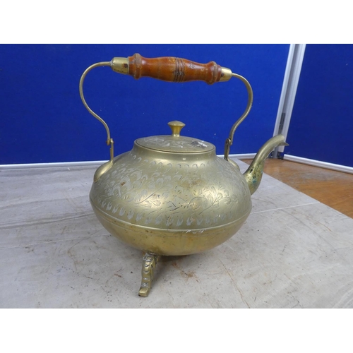 693 - A vintage brass teapot with wooden handle.