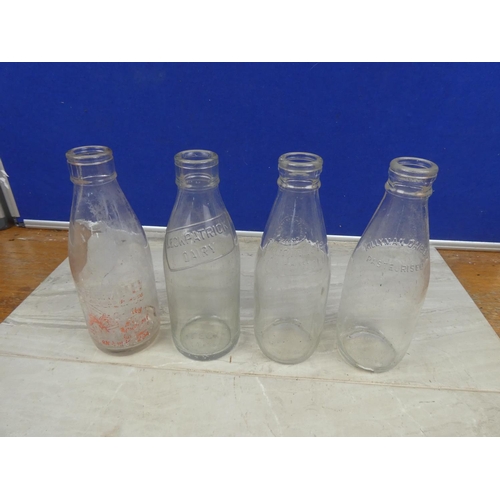 1121 - Four vintage milk bottles.