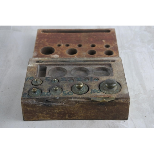 55 - A set of antique brass weights in a wooden storage box.