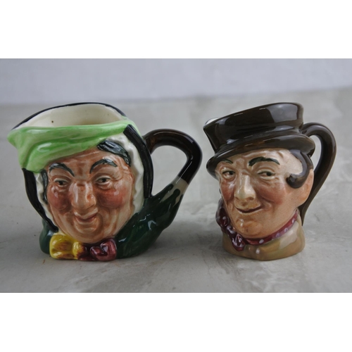 67 - Two miniature Royal Doulton mask jugs.