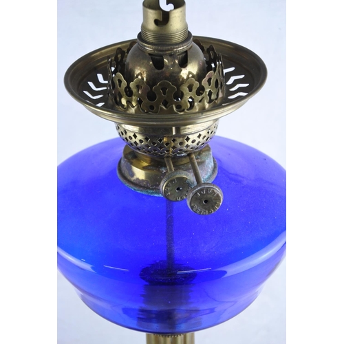 78 - A stunning antique brass oil lamp with blue glass font. (Electric conversion) Approx 52cm.