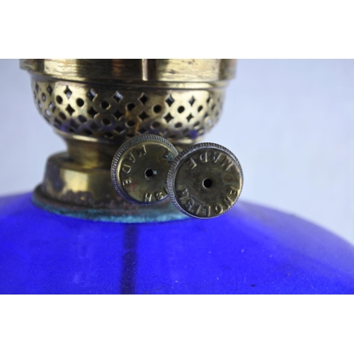 78 - A stunning antique brass oil lamp with blue glass font. (Electric conversion) Approx 52cm.