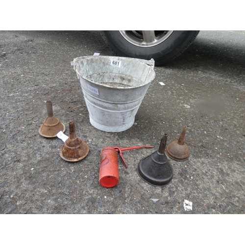 681 - A small vintage bucket and a lot of vintage oil funnels and an oil can.