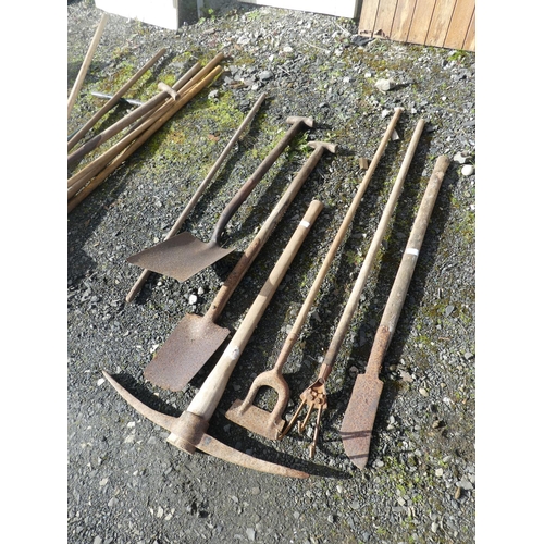 735 - A lot of garden tools, a large pickaxe and more.