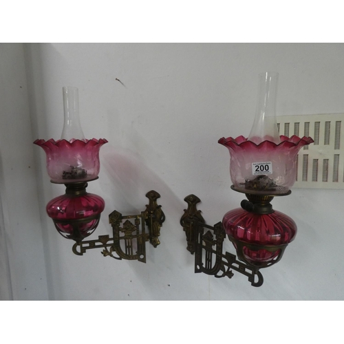 200 - A stunning pair of ruby glass oil lamps with gilt metal wall brackets & decorative glass shades. (1 ... 