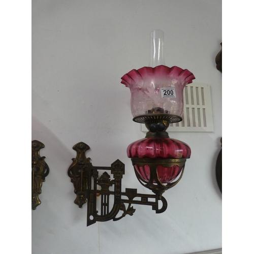 200 - A stunning pair of ruby glass oil lamps with gilt metal wall brackets & decorative glass shades. (1 ... 