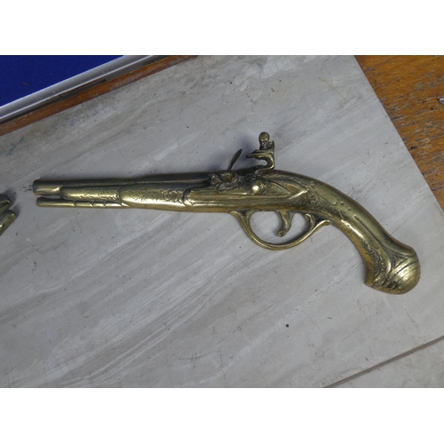 206 - A pair of vintage brass pistol wall plaques.